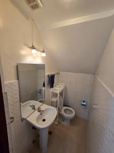 a bathroom with a sink and a toilet at Beautiful four bedroom home in Talisay