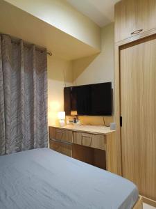 une chambre avec un lit et une télévision à écran plat dans l'établissement Modern Condo,Pool, Avida Riala Tower1, à Cebu