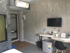 Una habitación con un escritorio y un televisor en la pared. en Hide & Seek Resort Krabi, en Ao Nang Beach