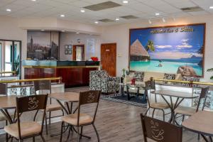 a restaurant with tables and chairs and a large mural at Atlantic Inn and Suites - Wall Township in Wall Township