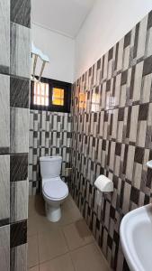a bathroom with a toilet and a sink at Résidence Agbevivi in Aného