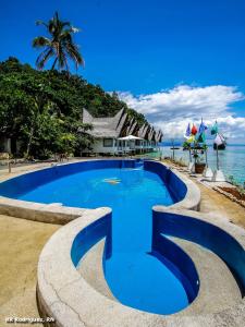 - une piscine à côté de l'océan sur une plage dans l'établissement Club Tara Island Resort, à Socorro