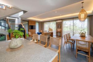 a dining room and living room with a table and chairs at Renjana Villas in Ubud