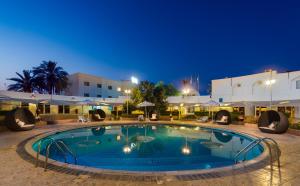 a large swimming pool in a resort at night at Al Wadi Hotel in Sohar