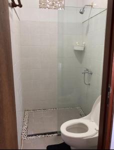 a bathroom with a toilet and a glass shower at RBE Hotel Kuta 2- 5 Min to Airport&Beach by Micky Studio in Ngurah Rai International Airport