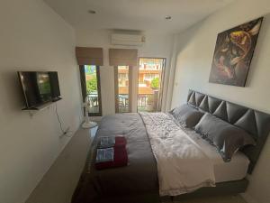 a bedroom with a large bed and a television at Lamai Beachroad Apartment in Lamai