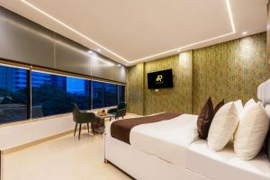 a bedroom with a bed and a desk and a window at Accent Park Hotel Near Barclays Sec 62 Noida in Noida