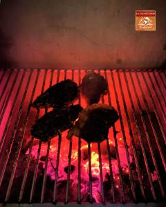 a grill with some food on top of it at La Casa de Darío - Hospedaje y Casa de Campo en Oxapampa con Piscina in Oxapampa