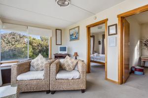 Summertime Cottage في Southport: غرفة معيشة مع كرسيين ونافذة