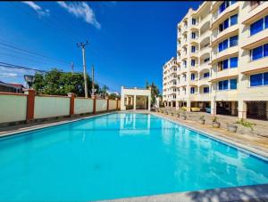 a swimming pool in front of a building at Ary Homestay Nyali - Next to Nyali Center in Mombasa