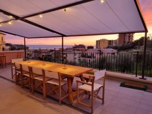 Una mesa y sillas de madera bajo un dosel en un balcón. en Sea & Fitness Villa, en Chiavari