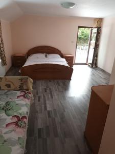 a bedroom with two beds and a wooden floor at Casa Cerbului Moisei in Moisei