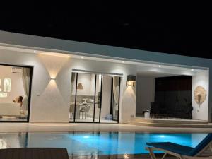 a villa with a swimming pool and a living room at Villa Ghalya in Al Maqārisah