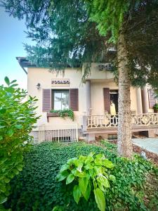 a house with a tree in front of it at Fészek Fogadó - Pension Nest in Mosonmagyaróvár