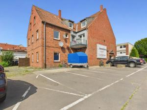 a parking lot with a blue truck parked in front of a building at FlexiFlats in Lingen