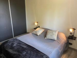a bedroom with a bed with two pillows on it at Koh Samui in Colomiers