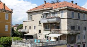 ein großes Backsteingebäude mit einem Balkon und einem Dach in der Unterkunft Apartments Centrum Split in Split
