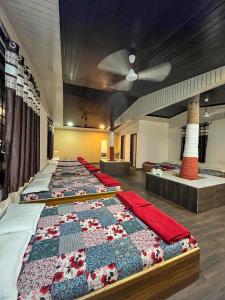 a row of beds in a room with a quilt at Swarg Resort in Pune