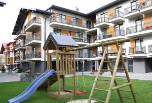 un parco giochi di fronte a un condominio di Tatjanos apartamentai a Palanga