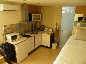 a small kitchen with a microwave and a bed in a room at Sitges Studio in Sitges