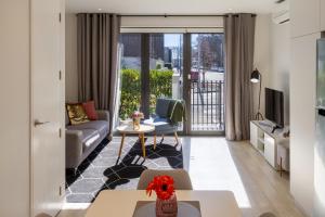 a living room with a couch and a table at Stadium Edge Retreat Modern 2-Bed plus Carpark in Christchurch