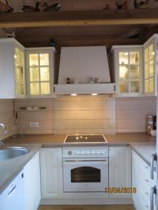 a kitchen with white cabinets and a stove top oven at Apartments Montana in Fužine