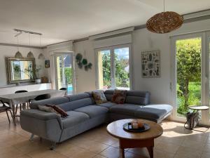 a living room with a couch and a table at Villa "La Tourelle" avec piscine privée in Haguenau