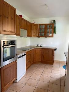 a kitchen with wooden cabinets and white appliances at Villa "La Tourelle" avec piscine privée in Haguenau