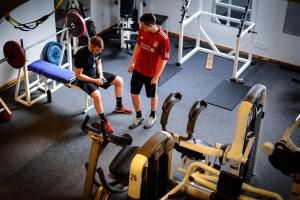 twee jonge mannen in een sportschool met gewichten bij Fyrtårn Tommerup Hostel in Tommerup