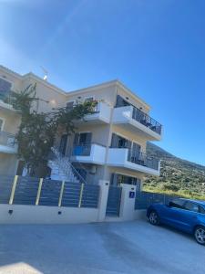 una macchina blu parcheggiata di fronte a un edificio di Anesi Vista Apartment a Vassiliki
