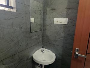 a bathroom with a sink and a mirror at Hotel Eleven Space Kochi in Cochin