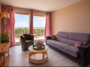 a living room with a purple couch and a table at Au Calme VUE MER in Saint-Brévin-lʼOcéan