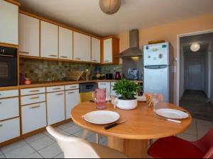 a kitchen with a wooden table and a blue refrigerator at Au Calme VUE MER in Saint-Brévin-lʼOcéan +31 photos