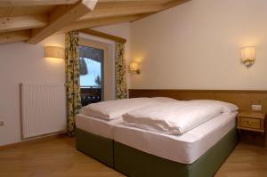 a bedroom with a bed in a room with a window at Residence Villa Funtanes in Selva di Val Gardena