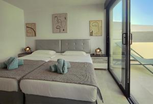 a bedroom with two beds with towels on them at VillasRoyale Rex - no steps, easy access, heated pool & BBQ in Meloneras +22 photos