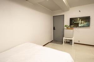 a bedroom with a bed and a tv on the wall at Hillzo stay in Seoul