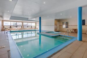 a large swimming pool with blue columns in a building at Comfort Inn Rutland - Killington in Rutland