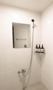 a shower in a white tiled bathroom at Hillzo stay in Seoul +22 photos