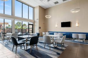 a waiting room with tables and chairs and a tv at Comfort Inn Aikens Center in Martinsburg
