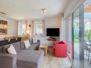 a living room with a couch and a tv at Chalet in Niedernsill near Ski Slopes in Niedernsill