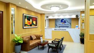 a waiting room with a brown leather couch and chairs at Jomtien Wave Residence in Jomtien Beach