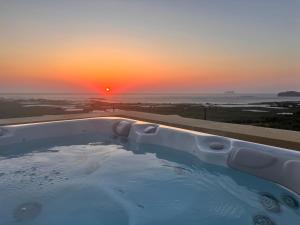 a hot tub with a sunset in the background at Falasarna's Dream in Kissamos +40 photos