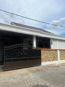 a house with a gate in front of it at Olive Homestay in Talang Kelapa