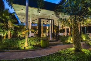 un edificio con palme di fronte di Mulberry Hotel a Siem Reap