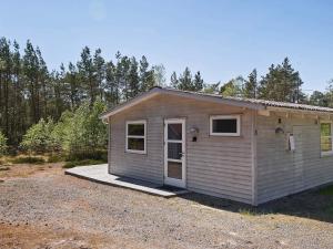 a small house is sitting in a gravel lot at 4 person holiday home in Nexø in Neksø