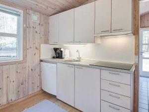 a kitchen with white cabinets and a sink at 4 person holiday home in Nexø in Neksø