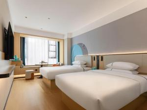 une chambre d'hôtel avec deux lits et une cuisine dans l'établissement City Comfort Inn Wuhan Hankou Railway Station West Square, à Wuhan 228 autres photos