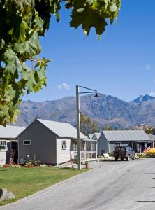 a row of houses with mountains in the background at Hampshire Holiday Parks - Arrowtown in Arrowtown