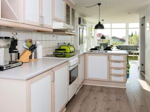 a kitchen with white cabinets and white appliances at 6 person holiday home in Hejls in Hejls