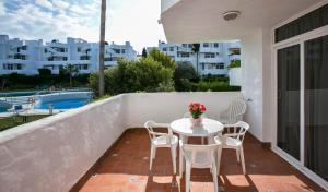 a balcony with a table and chairs and a pool at Ona Campanario in La Cala de Mijas